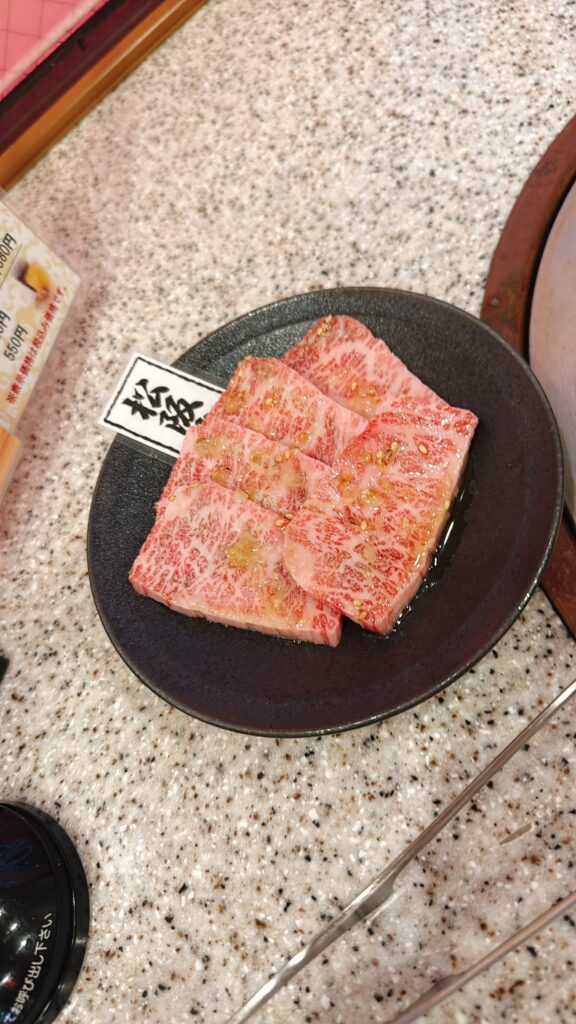 細かな霜降りが美しい松阪牛の焼肉用スライスを黒い皿に盛り付けた様子