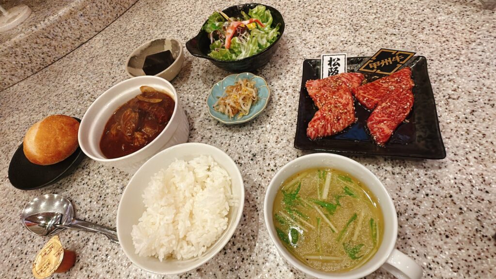 松阪牛の焼肉とご飯、スープ、煮込み料理、サラダが付いた食事セット